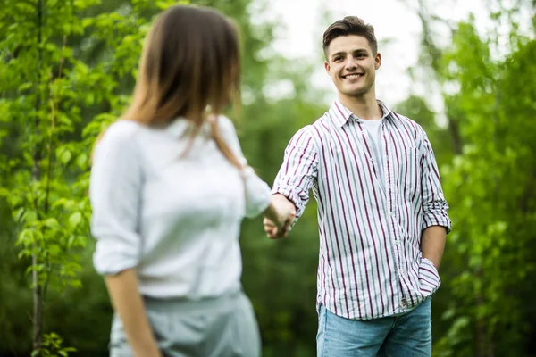 Ζευγάρι περπάτημα χέρι-χέρι σε ένα πάρκο. Ρομαντική ημερομηνία σε εξωτερικούς χώρους — Φωτογραφία Αρχείου