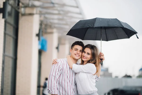 快乐的年轻夫妇拥抱下伞在雨天。情侣恋爱关系的概念. — 图库照片