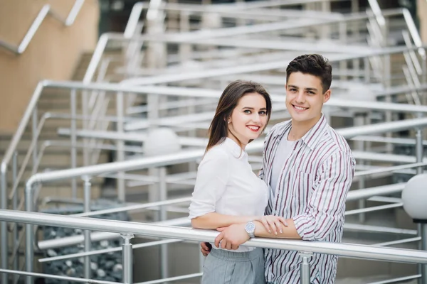 Romantic young couple standing on stairs outdoors in the city street — Stock Photo, Image