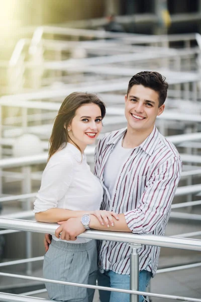 Romântico jovem casal apaixonado de pé em escadas ao ar livre na rua da cidade perto do edifício — Fotografia de Stock