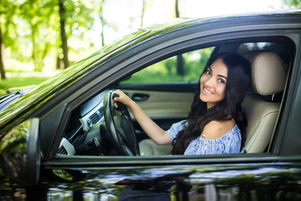 Hermosa mujer joven en el buen coche se ve feliz y relajado se va de vacaciones . — Foto de Stock