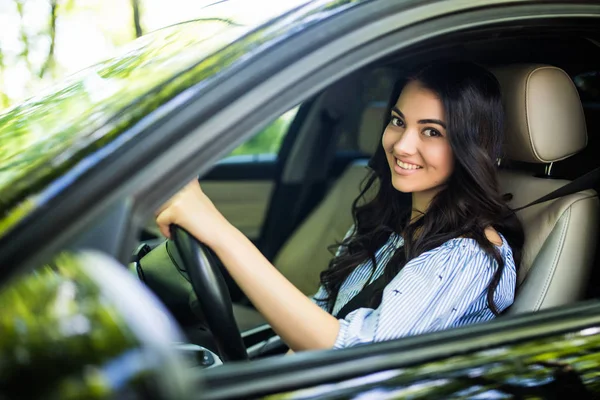 Una mujer joven y bonita conduciendo su auto nuevo. Womanm coche en coche en la ciudad — Foto de Stock