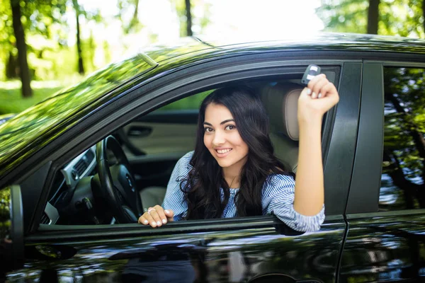 Motorista feminina feliz mostrando a chave do carro em seu novo carro — Fotografia de Stock