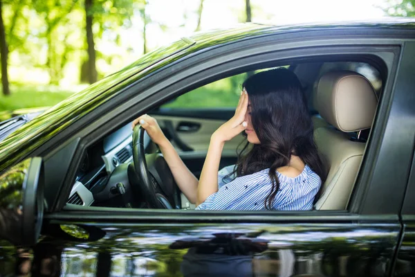 Masalah di jalan, gadis menyentuh dahinya dengan tangan sementara di mobilnya — Stok Foto