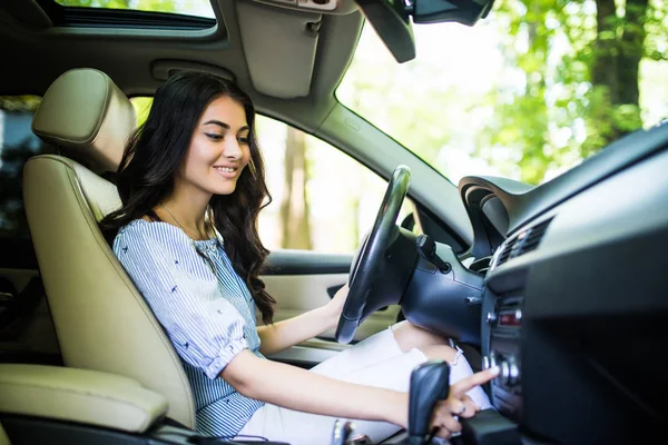 Jeune beauté femme changer de station à la radio à la voiture de conduite à la maison . — Photo