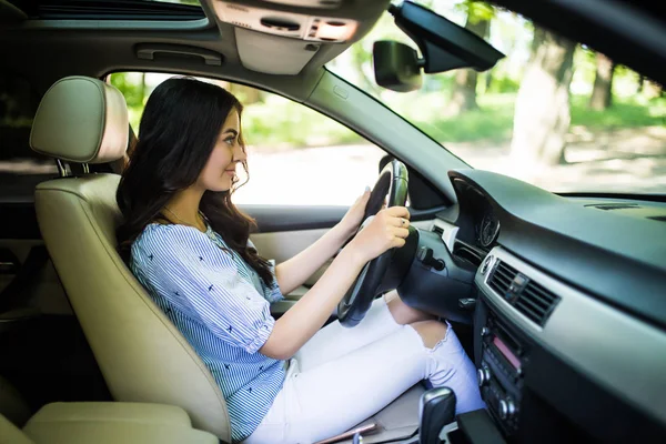 Mujer joven concentrada en un coche en la carretera — Foto de Stock