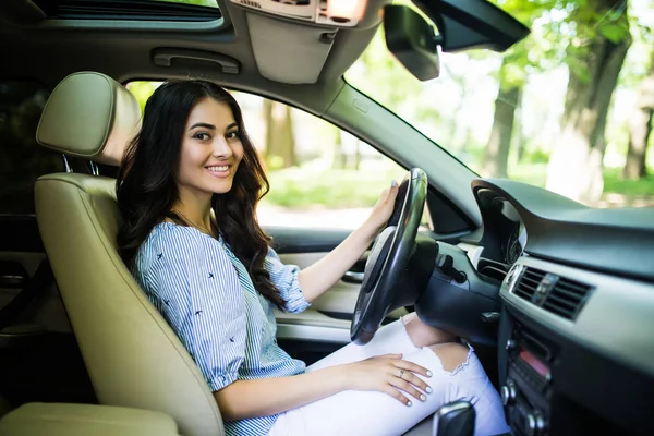 Gadis cantik yang tersenyum muda mengendarai mobil di kota — Stok Foto