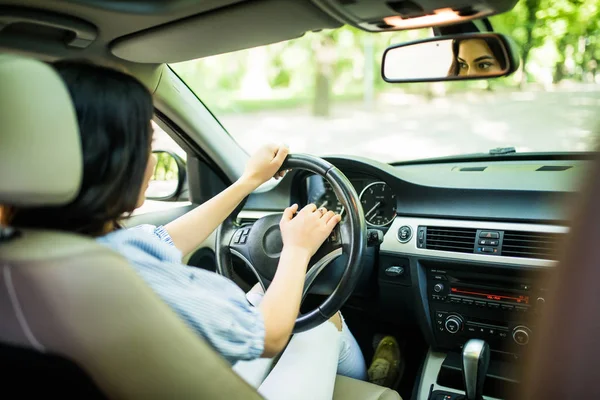 Jeune femme main appuyant sur le bouton de klaxon tout en conduisant une voiture à travers la route. Femme conduisant une voiture avec la main sur le bouton corne . — Photo