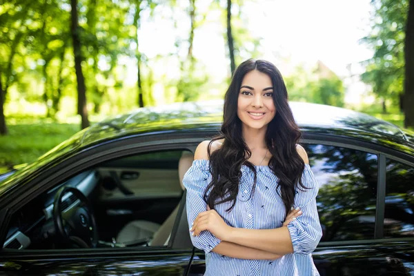 Jovem mulher de beleza de pé perto de carro novo, inclinando-se em auto — Fotografia de Stock