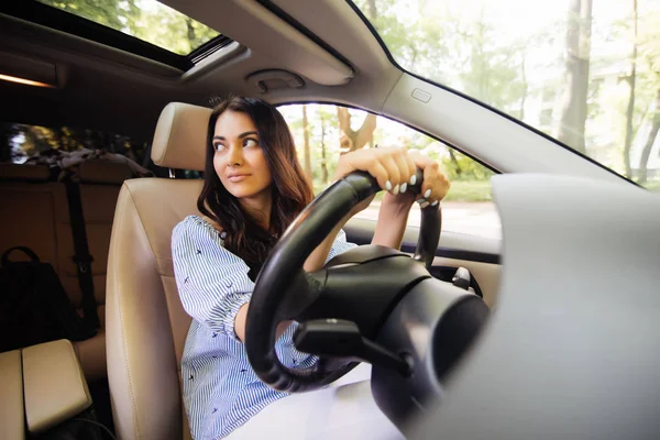 Веселая молодая женщина учится водить на своей машине — стоковое фото