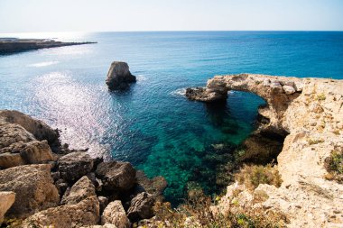 Kıbrıs, Avrupa 'daki Ayia Napa yakınlarındaki doğal taş köprüde güzel bir günbatımı. Aşk köprüsü.