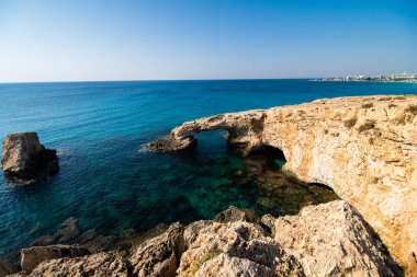Kıbrıs, Avrupa 'daki Ayia Napa yakınlarındaki doğal taş köprüde güzel bir günbatımı. Aşk köprüsü.
