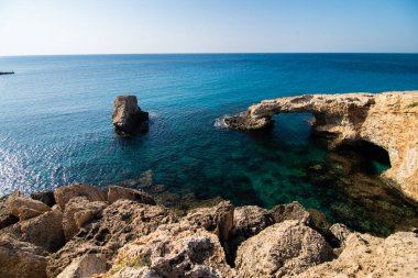 Kıbrıs, Avrupa 'daki Ayia Napa yakınlarındaki doğal taş köprüde güzel bir günbatımı. Aşk köprüsü.