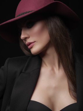 Siyah yün ceket, dikişsiz iç çamaşırı ve kafasına vinous geniş kenarlı şapka zarif ve gizemli bir genç bayan Portresi, stüdyo photoshoot