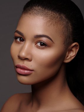 Mükemmel pürüzsüz parlayan cilt, tam dudaklar ve tıraşlı saç kesimi, stüdyo çekimi, koyu arka plan ile olağanüstü güzel bir Afro-Amerikan modeli moda portre