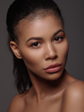 Mükemmel pürüzsüz altın deri, tam dudaklar ve tıraşlı saç kesimi, stüdyo çekimi, koyu arka plan ile olağanüstü güzel bir Afro-Amerikan genç kadının Moda portre