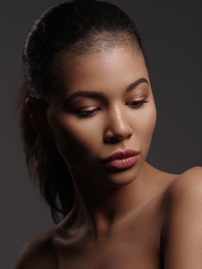 Mükemmel pürüzsüz parlayan cilt, tam dudaklar ve tıraşlı saç kesimi, stüdyo çekimi, koyu arka plan ile olağanüstü güzel bir Afro-Amerikan modeli moda portre