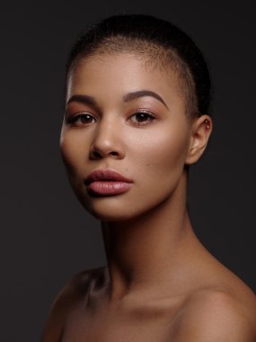 Mükemmel pürüzsüz parlayan cilt, tam dudaklar ve tıraşlı saç kesimi, stüdyo çekimi, koyu arka plan ile olağanüstü güzel bir Afro-Amerikan modeli moda portre
