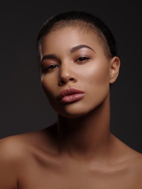 Mükemmel pürüzsüz parlayan cilt, tam dudaklar ve tıraşlı saç kesimi, stüdyo çekimi, koyu arka plan ile olağanüstü güzel bir Afro-Amerikan modeli moda portre