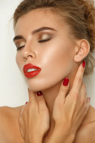 Modieuze contrastrijke portret van een sexy mooie jonge vrouw met perfecte make-up (gladde gloeiende huid, brede verzorgde wenkbrauwen, rode lippenstift en smokey eyes), studio shoot, lichte achtergrond — Stockfoto