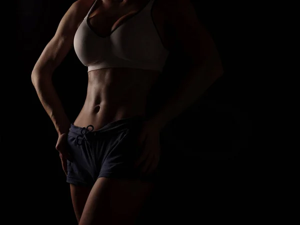 Mujer joven atlética y sexy en una camisa deportiva blanca y pantalones cortos azules —  Fotos de Stock