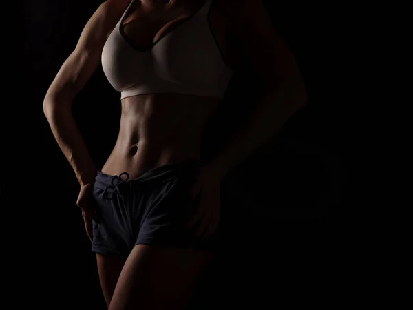 Mujer joven atlética y sexy en una camisa deportiva blanca y pantalones cortos azules — Foto de Stock