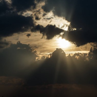 Fırtına bulutları arasında güneş ışınları.