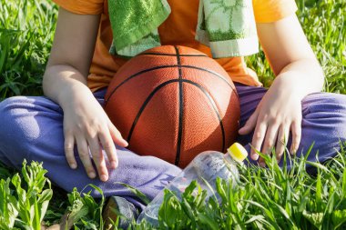 Bir çocuğun elinde basketbol topu.