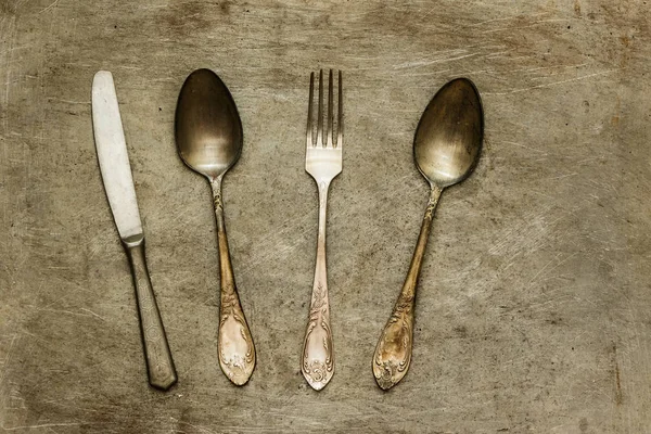 Eski kaşıklar çatal ve bıçak metal bir arka planda.
