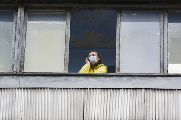 Girl in medical mask in an old quarantined hospital