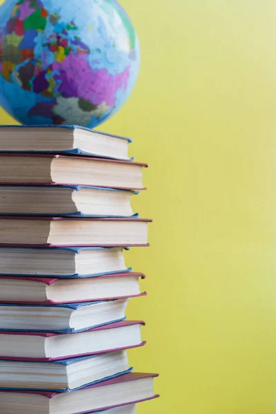 Alta pilha de livros com globo e espaço de cópia . — Fotografia de Stock