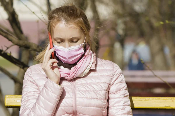 Maskeli genç bir kadının portresi telefonda konuşuyor..