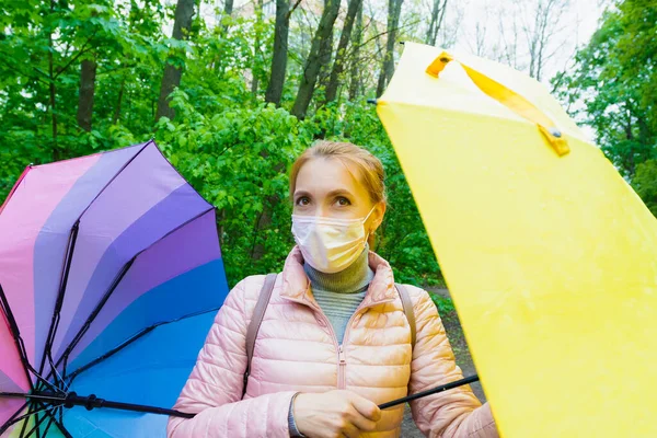 Jonge Vrouw Een Medisch Masker Met Gekleurde Paraplu Wandelingen Het Rechtenvrije Stockafbeeldingen