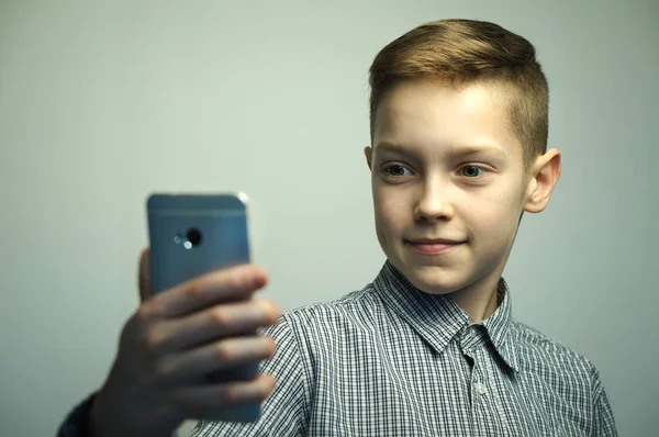 スマート フォンで selfie を取ってスタイリッシュな散髪と深刻な 10 代の少年 — ストック写真