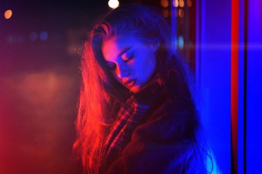 Gece şehir dramatik neon arka plan üzerinde poz seksi genç kadın