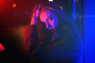 Gece şehir dramatik neon arka plan üzerinde poz seksi genç kadın