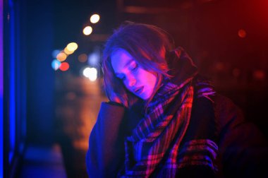 Gece şehir dramatik neon arka plan üzerinde poz seksi genç kadın