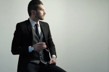 Takım elbise giymiş bir stüdyoda bardaklarda yakışıklı genç