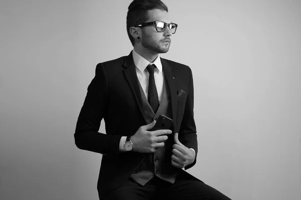 Przystojny, młody człowiek w okularach w studio na sobie garnitur — Zdjęcie stockowe