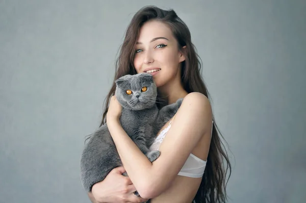 自宅で安静時猫と下着で美しいブルネットの少女 — ストック写真