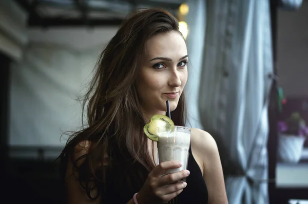 カフェ屋外でフルーツとチョコレートのミルクセーキを飲む女性 ストック写真