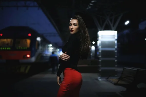 Elegante viajera mujer esperando tren en la estación de tren de la noche — Foto de Stock