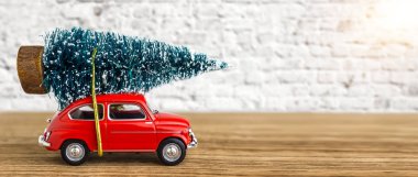 Bir Noel ağacı taşıyan kırmızı araba
