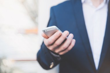 İş adamı elinde telefonla.