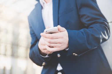 İş adamı elinde telefonla.