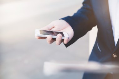 İş adamı elinde telefonla.