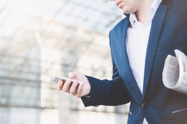 İş adamı elinde telefonla.