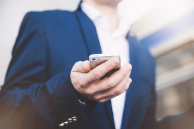 İş adamı elinde telefonla.