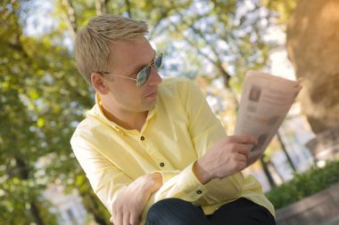 Gazete onun elinde olan adam.