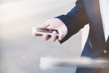 İş adamı elinde telefonla.